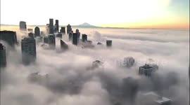 Impressive footage shows dense fog rolling into downtown Seattle at sunrise on Christmas Eve