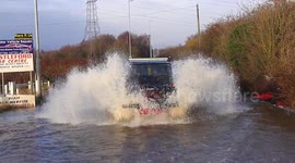 Landrover drives through flooded street after Storm Bella in West Yorkshire
