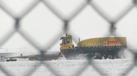 Snowploughs work to clear runway of UK's East Midlands Airport as heavy snowfall hits the area