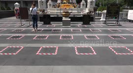 Buddhist devotees stand in squares for social distancing amid Covid-19 surge in Thailand