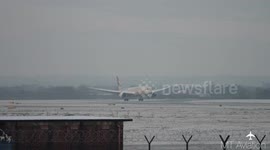 Aircraft lands at Manchester Airport as snow blankets runway