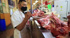 A butcher Mexican cuts a head of beef in one of the shops of the Municipal Market during food sales for the New Year's dinner