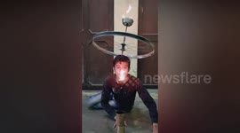 Incredible moment 15-year-old flaunts his balancing skill by rotating a cycle rim with a bowl of fire on the top of his head in northern India