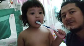 father n doughter sharing toothbrush