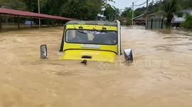 Rescue jeeps drive through flooded village in Malaysia