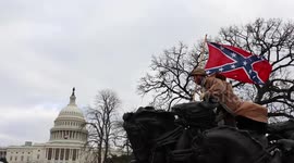 Trump supporter waves Confederate flag upon statue as mob ransack Congress