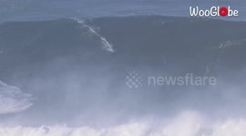 Surfer Rides Huge Waves in Nazare, Portugal