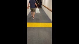 Man walking loudly through a corridor wearing flip flops