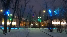 Snow-covered Moscow boulevard with street lamps changing colours
