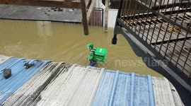 Food delivery man wades through floods in Thailand