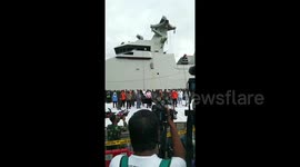 Crowd gathers to see rescuers examine items retrieved from downed Indonesia plane as relatives await news