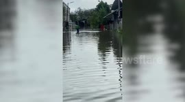 Food delivery man wades through floods after heavy rain in Thailand