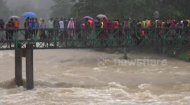 Extreme fishing! Locals swim through raging river to catch their supper after dam was opened during floods