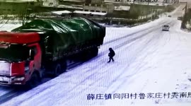 Chinese men use stones to stop truck sliding down icy road in its tracks