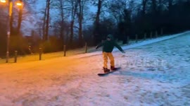 Snowboarder cruises down hill in southeast England after overnight snow