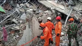 Rescuers attempt to remove trapped Indonesian earthquake victims from collapsed building