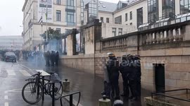 Black bloc members attack police officers during a protest against