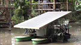 A solar powered machine paddles water in a pond to keep it fresh, it speeds up when the sun shines brightly and slows down when we get clouds.