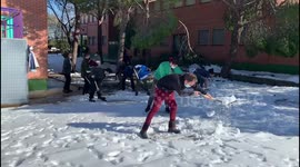 Families clean the snow from access to schools in Madrid 17th January, 2021.