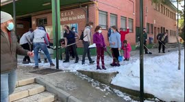 Families clean the snow from access to schools in Madrid 17th January, 2021.