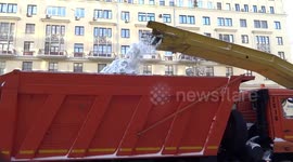 Snow plow and a truck work together to clear snow off Tverskaya Street in Moscow