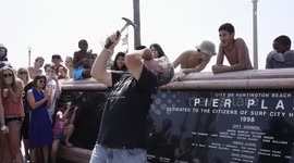 Street performer hammers a nail into his face