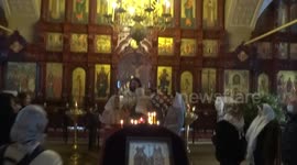Priest calms down baby in Russian church on the Orthodox Epiphany day