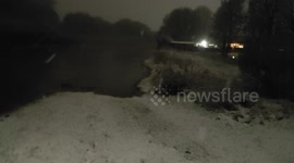 Snow falls as UK road left submerged by Storm Christoph