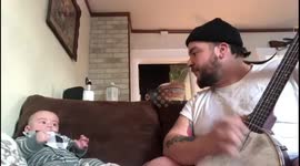This baby is a fan of his dad's banjo playing as he dances along