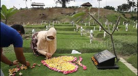 Indonesian woman visits tombstone of husband who died from COVID-19