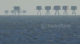 Ship passing in between the Red & Shivering Sands wartime forts off Kent, UK