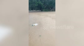 Man floats on old mattress during Malaysia floods