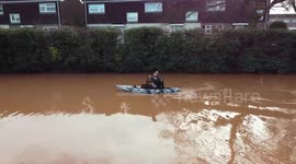 Man kayaks in flooded street after river bursts its banks in Hereford, England