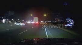 Drifting car nudges truck and slams into concrete barrier
