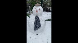 Children build snowman in London snow