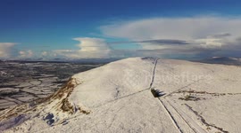 Drone view of snow-topped Benbradagh mountain In Northern Ireland's Donegal