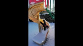 Going down the slide head first in the snow.