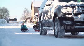 4x4 tows sledging kids as they enjoy the snowy weather in Derbyshire, UK