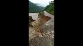 Chunk of road is swept away by floodwater metres away from filmer in Bolivia