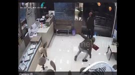 Chilling moment armed robbers fire at brave jeweler who fights them off with bare hands