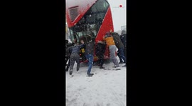 Londoners team up to shift bus stuck in snow during winter storm