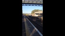 Irish Rail passenger train passing through station at speed