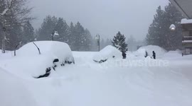 Heavy snow buries cars parked at a gas station