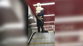 Woman forced to carry adorable puppy afraid of escalators