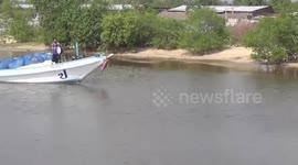 Fisherman tilt boats sideways to pass under low bridge