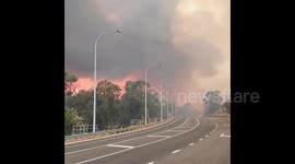Raging bushfire encroaches on highway as it burns through hillside near Perth