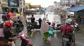 Heavy rain and trash in the sewers caused floods to submerge homes and block roads