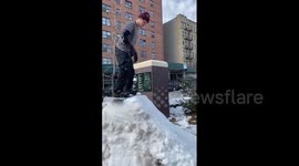 Snowboarder performs tricks in New York City park