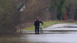 Cyclist battles through floods on a road in West Yorkshire