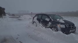 Road and cars buried in snow drifts